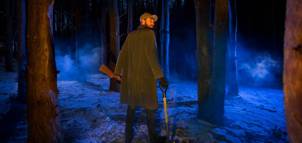 Armed man in the woods at night